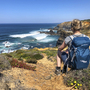 Person am Küstenpfad mit Blick auf das Meer und Klippen in Portugal.