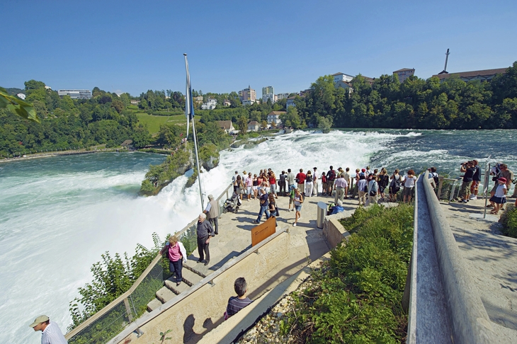 Besucher auf dem Belvedere-Weg am Rheinfall mit Blick auf das rauschende Wasser.