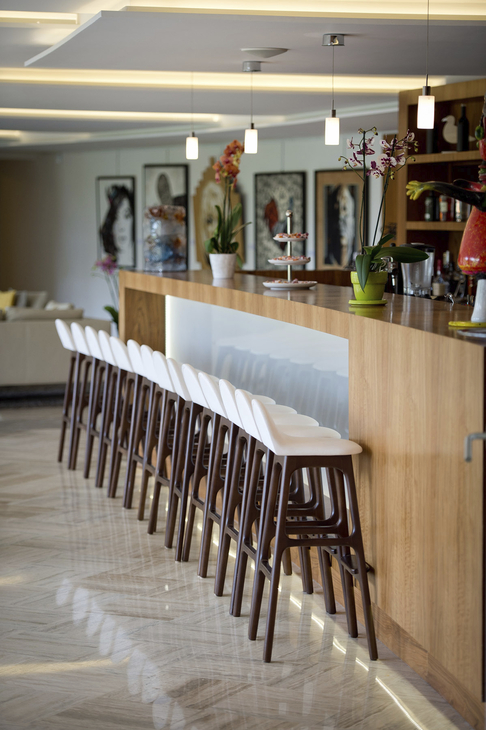 Moderne Hotelbar mit Holztresen und hohen Stühlen.