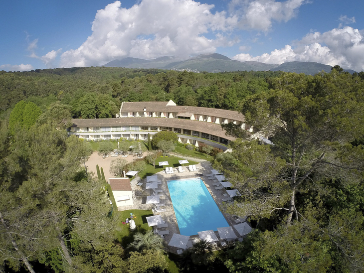 Luftaufnahme des Hotel La Vague in Saint Paul de Vence mit Pool und umliegenden Bäumen.