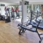 Fitnessstudio mit Laufbändern und Trainingsgeräten, Person auf Laufband.