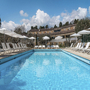 Poolansicht im Hotel La Vague in Saint-Paul-de-Vence mit Liegestühlen und Sonnenschirmen.