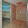 Innensicht einer modernen Sauna mit Holzwänden und Glastür.