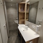 Modernes, renoviertes Badezimmer mit Dusche und Waschbecken.