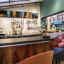 Moderne Hotelbar mit bunten Stühlen und einer großen Auswahl an Spirituosen.