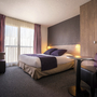 Hotelzimmer mit zwei Einzelbetten, moderner Einrichtung und Fenster ohne Balkon.