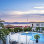 Hotelpool bei Sonnenuntergang mit Blick auf die Marina und die umliegenden Gebäude.