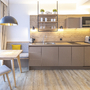 Moderne Küchenzeile mit Holztisch, Stühlen und Fenster.