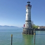 Leuchtturm auf dem Bodensee bei klarem Himmel und ruhigem Wasser.