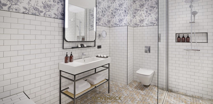 Modernes Badezimmer im Mövenpick Hotel Den Haag mit Dusche und Waschbecken.