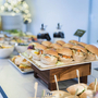 Buffet mit belegten Brötchen und Salaten auf einem Tisch.