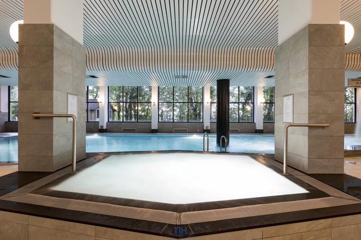 Innenansicht eines Konferenzzentrum-Pools mit Whirlpool im Vordergrund.