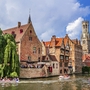 Kanal in der Altstadt von Brügge mit historischen Gebäuden und vorbeifahrenden Booten.