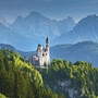 Schloss Neuschwanstein in Bayern, umgeben von grünen Wäldern und Bergen.