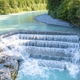 Wasserfall Lechfall in Füssen mit türkisfarbenem Wasser und Wald im Hintergrund.