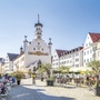 Rathaus von Kempten im Allgäu mit umgebenden Straßencafés an einem sonnigen Tag.