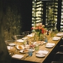 Eleganter gedeckter Tisch in einem stimmungsvoll beleuchteten Raum mit Blumenarrangement.