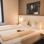 Schlafzimmer in der Ferienanlage Büsum, mit Doppelbett, Wandbild mit einer Möwe sowie einem Fenster mit Vorhängen.