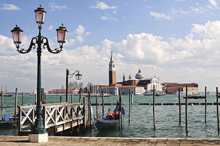 Blick auf den Dogenpalast in Venedig mit Laterne im Vordergrund.