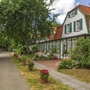 Haus auf Spiekeroog mit Garten und Allee im Sommer.