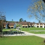 Wohnsiedlung mit Spielplatz und Bäumen vor blauem Himmel in Inzell.