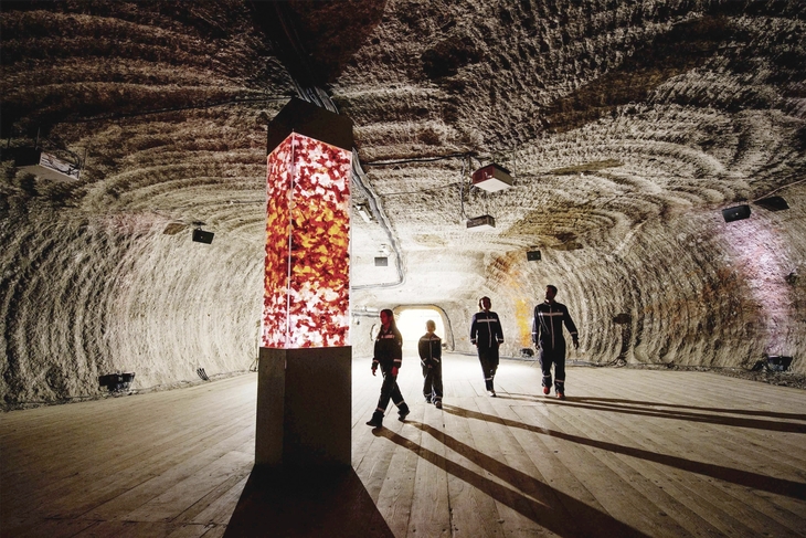 Personen im beleuchteten Salzraum des Salzbergwerks Berchtesgaden.