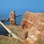 Rote Felsformation Lange Anna auf Helgoland im Meer bei blauem Himmel.