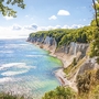 Kreideküste Rügens mit blauem Meer und grünem Wald.