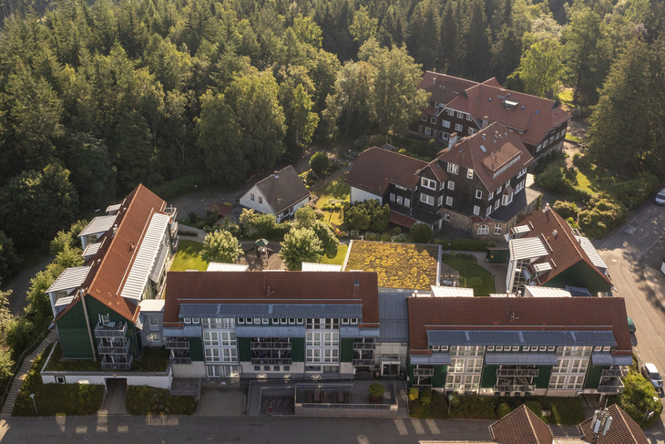 Luftaufnahme eines Erholungswerks mit mehreren Gebäuden und umliegendem Wald.
