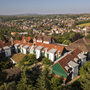 Luftaufnahme einer Wohnsiedlung am Rande einer Stadt mit bewaldeter Landschaft.