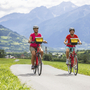 Zwei Radfahrer vor Bergkulisse auf Radweg bei Meran.