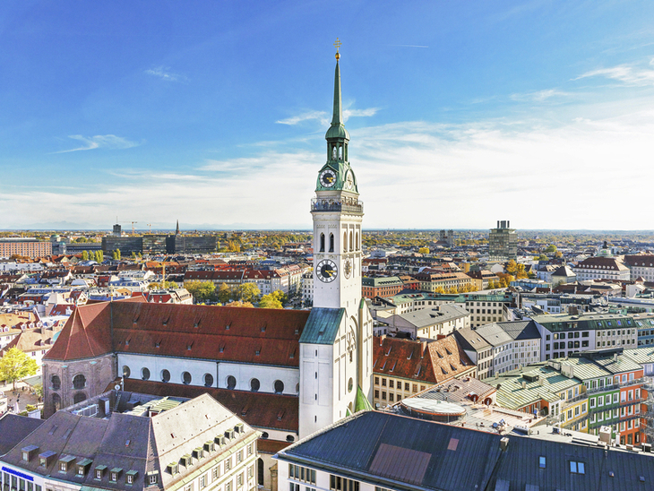 Luftaufnahme der Kirche St. Peter in der Münchner Innenstadt bei klarem Wetter.