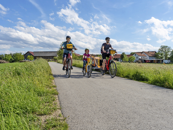 Familie beim Radfahren auf ländlichem Weg an einem sonnigen Tag