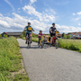 Familie beim Radfahren auf ländlichem Weg an einem sonnigen Tag