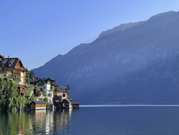 Fachwerkhäuser am Seeufer mit Berg im Hintergrund bei Hallstatt, Salzkammergut.
