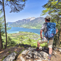 Wanderer mit Rucksack blickt auf See und Berge im Salzkammergut.