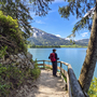 Wanderer mit Rucksack auf Weg am Wolfgangsee, Berge im Hintergrund