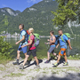 Menschen wandern am Hallstätter See in der Nähe von Bergen und Wasser.