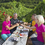 Gruppe von Wanderern bei einer Jause im Freien mit Wein und Essen