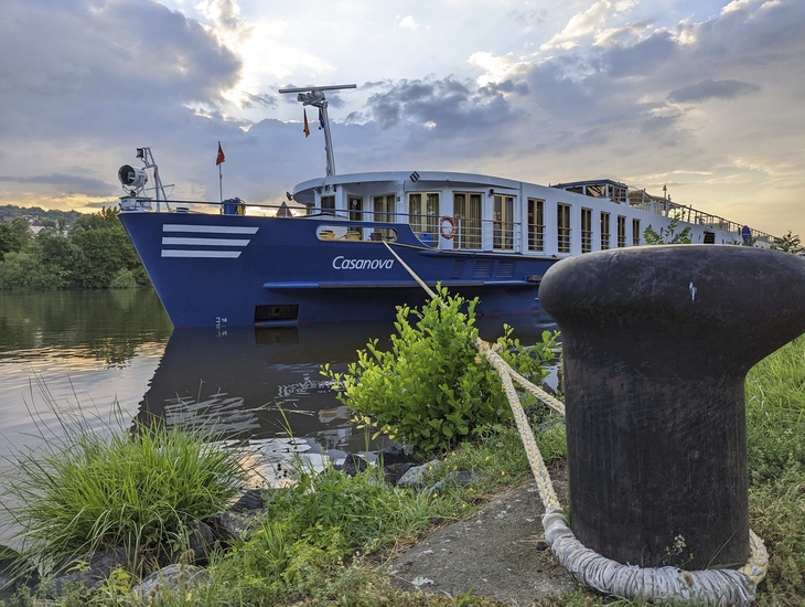 Kreuzfahrtschiff Casanova am Flussufer festgemacht, im Hintergrund bewölkter Himmel.