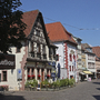 Straße in Karlstadt mit historischen Fachwerkhäusern bei klarem Himmel.